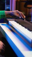 Vertical Music engineer producing song by mixing and mastering tunes on audio console, playing piano notes on synthesizer to record sounds on pc. Producer creating soundtracks with midi controller. Camera B. video