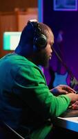 Vertical Confident music composer mixing sounds on digital audio software, creating a cool atmosphere in his home studio. Young cheerful producer composing new soundtracks with stereo gear. Camera A. video