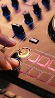 Vertical Audio engineer with headset mixing and mastering his recorded files, operating on a professional soundboard in home studio. Artist producer composing new tracks with sound effects. Camera A. video