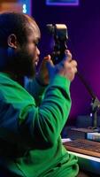 Vertical Artist composer recording a new track on his home studio microphone, editing his song with professional gear. Adjusting volume levels and adding sound effects, mix and master. Camera A. video
