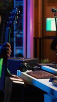 Vertical Musical producer prepares to record tunes on acoustic instrument, working in personal home studio to record soundtrack. Sound composer recording guitar music, editing with mixing console. Camera A. video