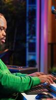 Vertical Audio technician works with recording tools in his home studio, using mixing console and pre amp knobs to add sound effects on tracks. Composer editing new tunes in post production. Camera A. video