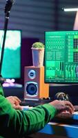 Vertical Creative songwriter recording new tracks with microphone and midi controller, playing piano notes in home studio. Skilled musician composing music with electronic keyboard and stereo gear. Camera A. video