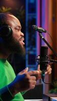 Vertical Confident songwriter performing a tune on microphone in home studio, recording his song and editing in post production. Performer artist singing aloud and using stereo equipment. Camera A. video