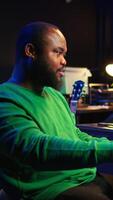 Vertical Modern producer playing piano keys to record new soundtrack, trying to produce song using midi controller electronic keyboard. Songwriter composer playing instrument notes to create tunes. Camera B. video