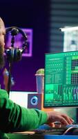 Vertical Sound engineer playing piano and mixing tunes on digital software, composing new songs and adding audio effects in post production. Artist composer creating soundtracks for music industry. Camera A. video