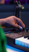 Vertical Music engineer producing song by mixing and mastering tunes on audio console, playing piano notes on synthesizer to record sounds on pc. Producer creating soundtracks with midi controller. Camera A. video