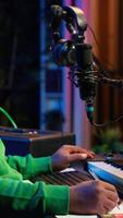 Vertical Skilled composer writing rhymes and lyrics to create new music in home studio, thinking about harmonic notes and verses to compose cool songs. Songwriter producing soundtracks with gear. Camera A. video