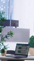 Vertical Laptop on desk in office showing stock exchange indices changing in real time. Notebook in workplace with forex trading indexes displayed live showing latest price modifications video