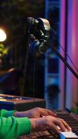 Vertical Talented artist composing new lyrics for his tracks and recording music with audio devices in his home studio. Singer composer writes melodic material by taking notes and creating rhymes or songs. Camera A. video