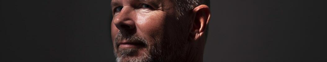 Man With Beard Posing Under Dramatic Lighting in a Minimalist Setting photo