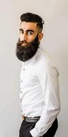 Muslim Man With a Big Beard Posing Elegantly Against a Neutral Background photo