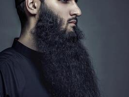 Muslim Man With a Beautiful Beard Posing Against a Dark Background photo