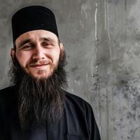 Muslim Man Smiling With a Beautiful Beard in a Minimalist Background photo