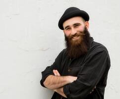 Smiling Muslim Man With a Beautiful Beard Posing Against a White Wall photo