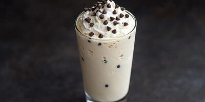 Creamy ice cream drink topped with whipped cream and chocolate chips photo