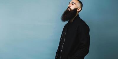 Muslim Man With a Beautiful Beard Posing Against a Blue Background photo
