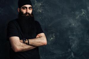Muslim Man With a Long Beard Posing Confidently Against Dark Background photo