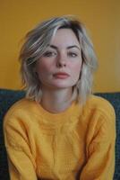 Young Woman Posing in Yellow Sweater Against Bright Background photo