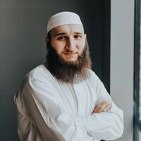 Muslim Man With a Beautiful Beard Posing by a Window in Natural Light photo