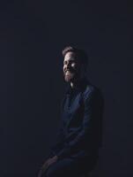Smiling Male Executive Posing Against Dark Minimalistic Background photo