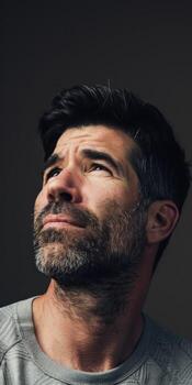 Man Gazing Upward With Thoughtful Expression in Indoor Setting photo