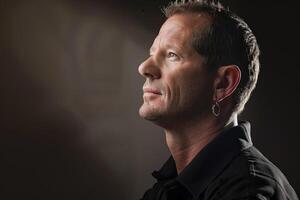 Thoughtful Man With Earring Poses in Soft Lighting photo