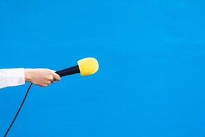 holding a yellow microphone with copy space, interview concept. photo