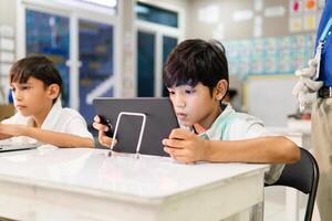Portrait of elementary students using technology. Academic and digitization concept. photo
