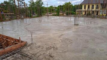 Construction worker pours concrete on the concrete floor of a building at a construction site photo