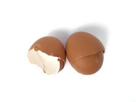 brown egg shell broken or crack with pieces scattered on the surface, isolated on white background, cut out photo