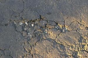 texture of cracked asphalt of the road with sunlight photo