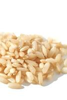 A top view of raw brown and white rice, forming a heap. The integral, uncooked grains highlight diverse Asian cuisine in this isolated pile. photo