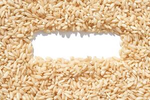 A rectangle frame captures a heap of brown basmati rice on a white background. The texture of long grains symbolizes nutrition and healthy cuisine, addressing hunger and poverty photo