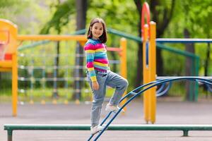 a little girl stand on the childrens stairs on the playground photo
