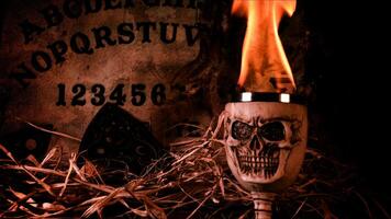 Creepy Skull on a Witchcraft Ouija Board and Candles photo