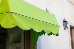 Green awning in front of a shop window. Blank space for printing logo or text. Perfect for storefront advertising and branding opportunities photo