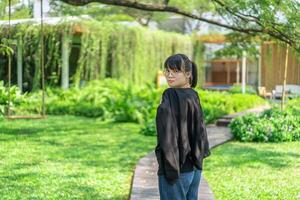 Portrait of the Asian glassese Thai woman is standing in the garden in the morning. photo