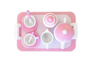 A set of pink white pastel color wood toy tea cups including 2 coffee cups with teaspoons, a teapot, a sugar jar and a milk jug is placed on a tray. Isolate clear on white background. photo