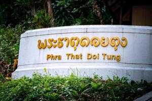 Gold text Banner in front of Stair, Thai Language mean Phra That Doi Tung, it's the name of the famous place and temple in Chiang Rai Province, North of Thailand. photo