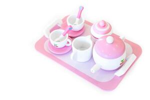 A set of pink white pastel color wood toy tea cups including 2 coffee cups with teaspoons, a teapot, a sugar jar and a milk jug is placed on a tray. Isolate clear on white background. photo