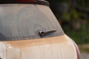 a lot of red brown dust on backside mirror car with one whisk of it. photo
