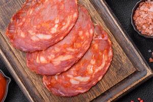 Delicious smoked meat sliced with salt, spices and herbs photo