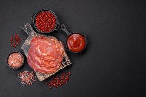 Delicious smoked meat sliced with salt, spices and herbs photo