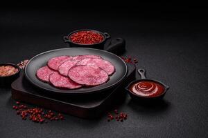 Delicious smoked salami sausage sliced with salt, spices and herbs photo