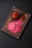 Delicious smoked salami sausage sliced with salt, spices and herbs photo