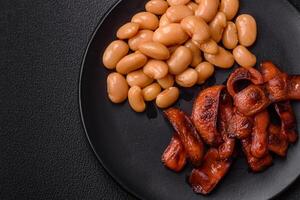 Fried sausages sliced with salt and spices as an ingredient for an English breakfast photo