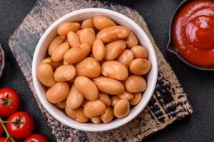 Delicious nutritious canned beans in tomato, with salt and spices photo