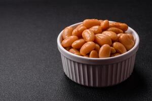 Delicious nutritious canned beans in tomato, with salt and spices photo