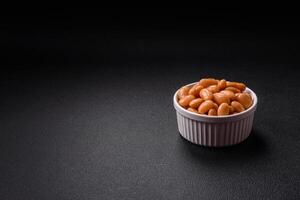 Delicious nutritious canned beans in tomato, with salt and spices photo